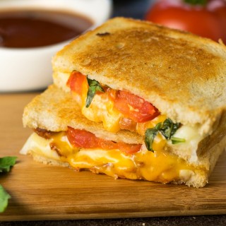 Gourmet grilled cheese with bacon, roasted tomato, and basil