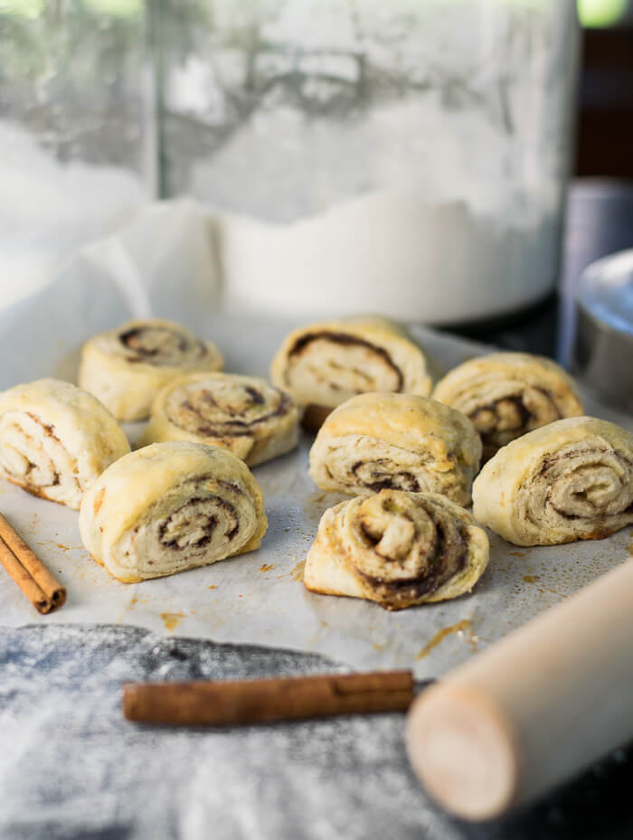 Pie Dough Pinwheels with cinnamon sticks and container of flour.