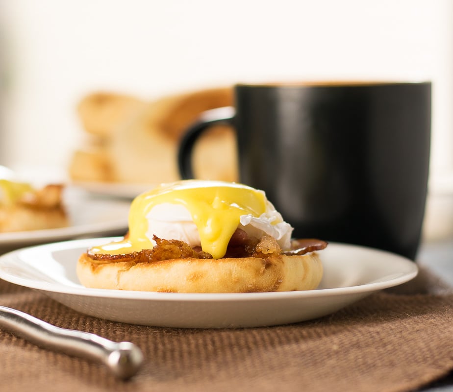 Close up look at Bacon and Eggs Benedict served with a fork.