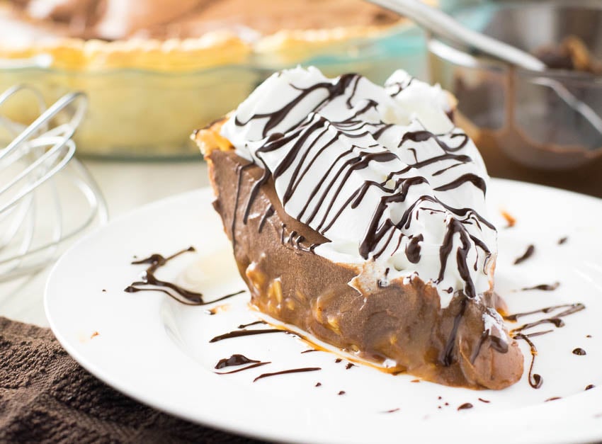 Caramel and Chocolate Marshmallow Cream Pie slice on a white plate.
