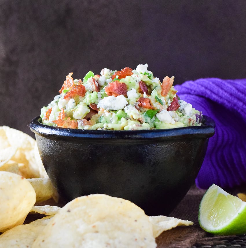 Blue Cheese and Bacon Guacamole Dip shown close up with a purple towel behind it.