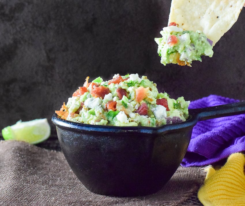 Tortilla chip dipping into guacamole.