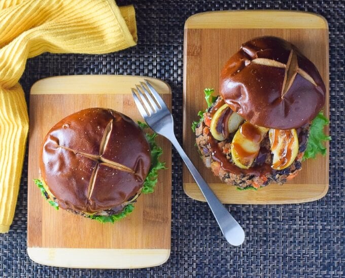 Two black bean burgers topped with pretzel buns shown from above.