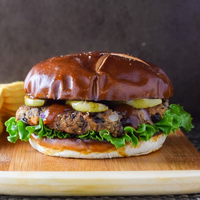 Black Bean Burger shown close up with BBQ sauce and seared apples.