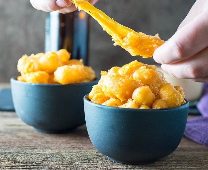 Beer Battered Deep Fried Cheese Curds being stretched to show cheese.