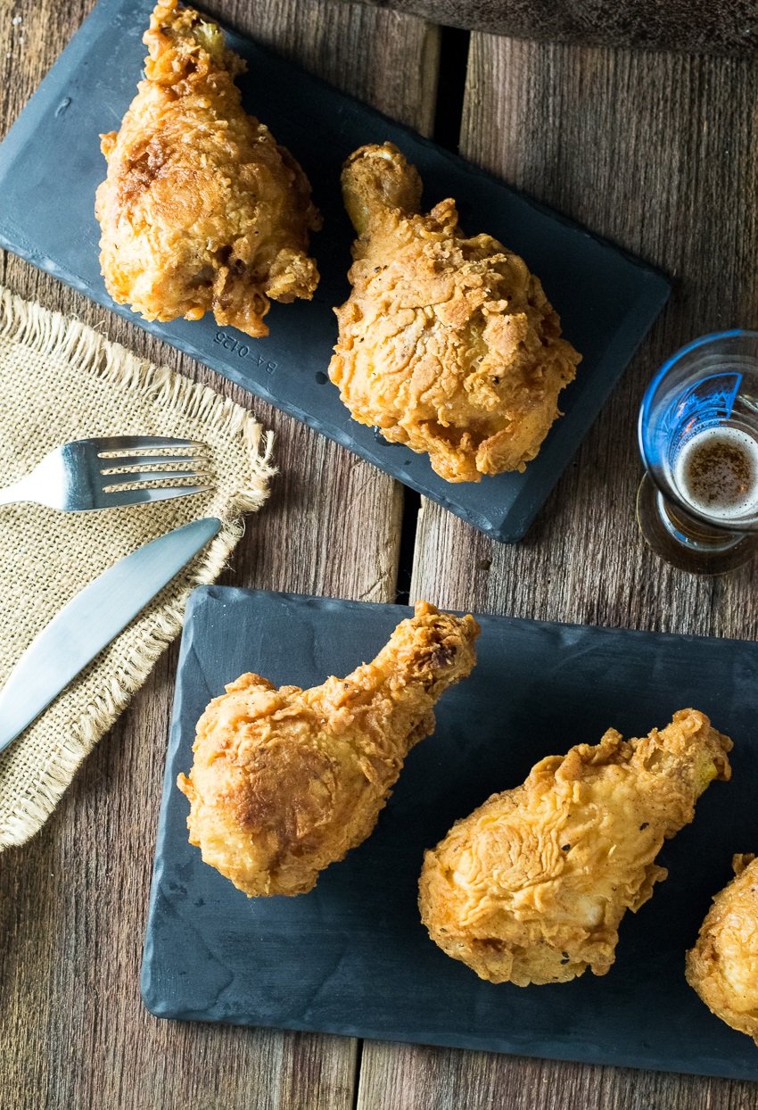 Crispy Beer Fried Chicken on black tray with glass of beer.