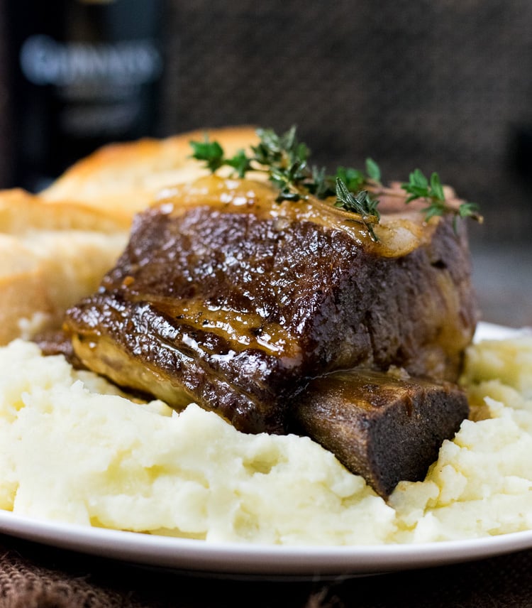 Beer Braised Short Ribs sitting on a pile of mashed potatoes.