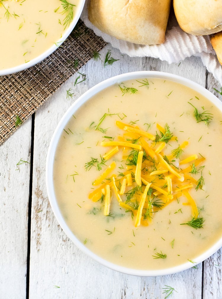 Serving bowl of cheesy potato dill soup.