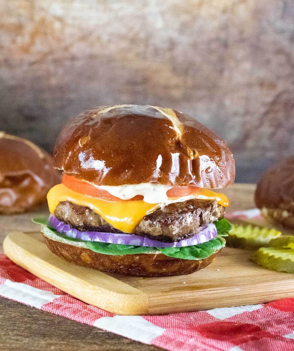 Homemade burger patty on pretzel bun with cheese