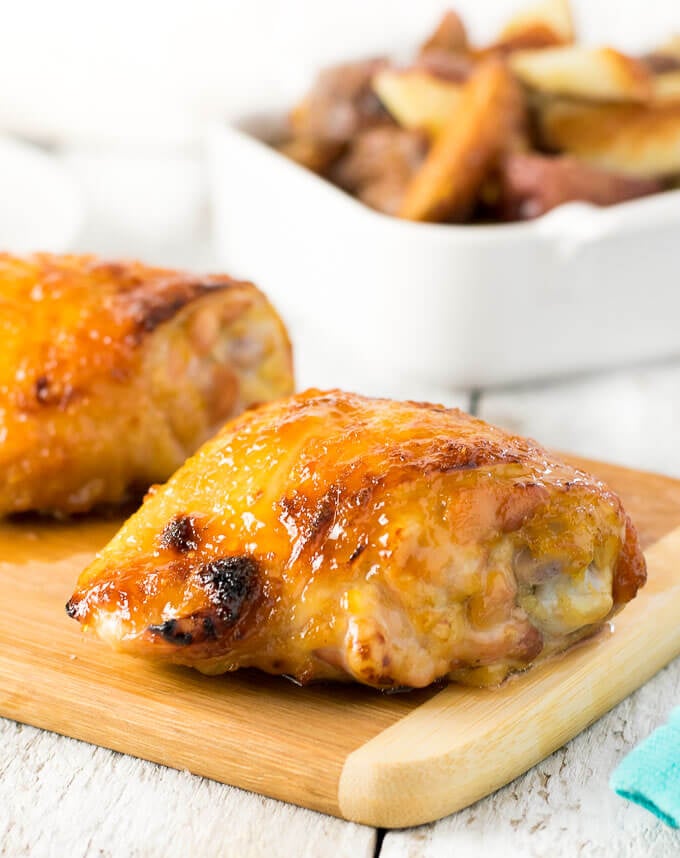 Sticky baked chicken thighs resting on cutting board