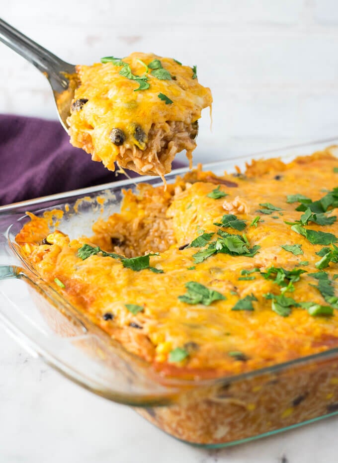 Easy Chicken Enchilada Casserole being scooped with silver spoon.