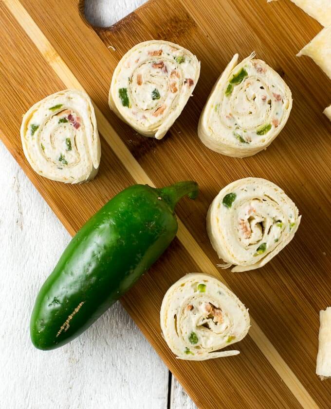 Jalapeno popper rollups on a cutting board.