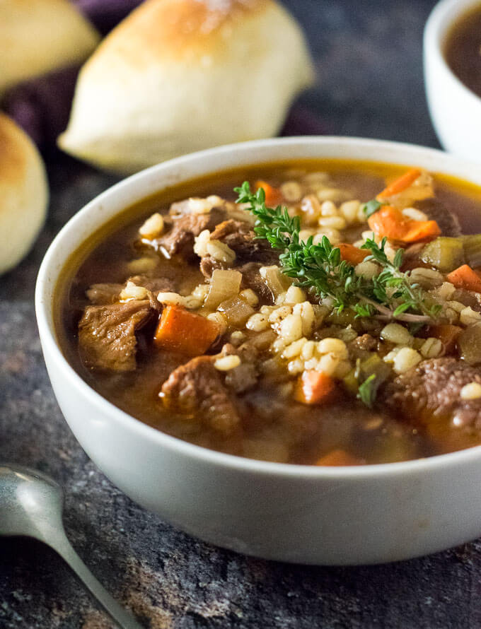 Crock Pot Beef and Barley Soup in white bowl viewed close up.