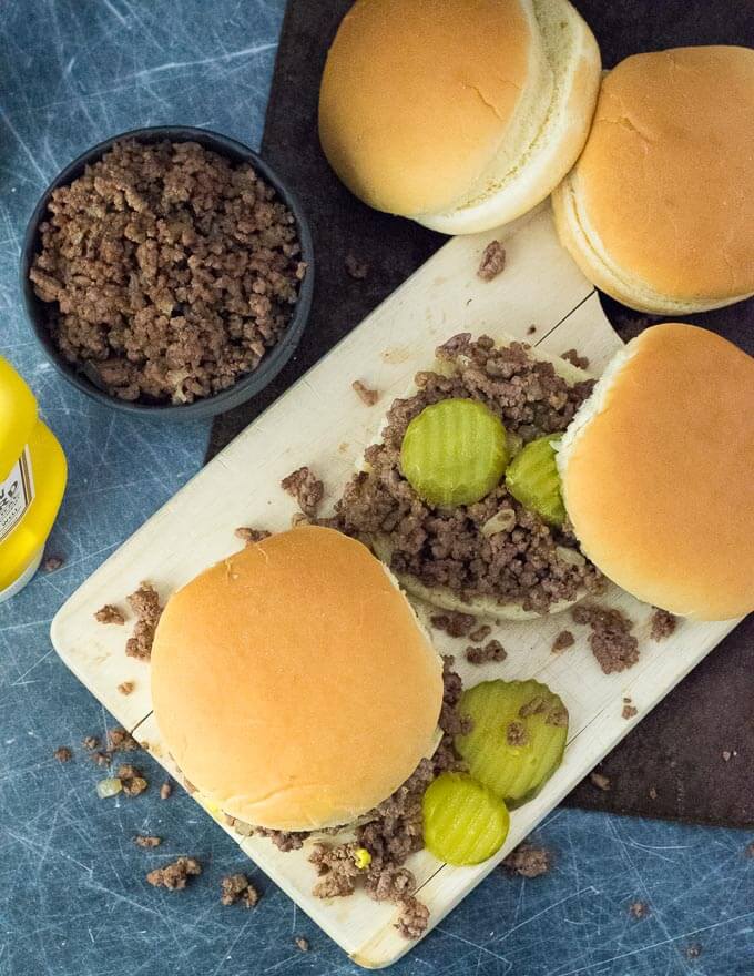 Loose meat sandwiches being made on cutting board.