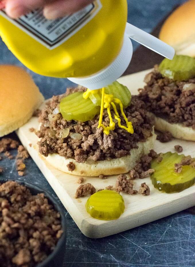 Loose Meat Sandwich with pickles and mustard.