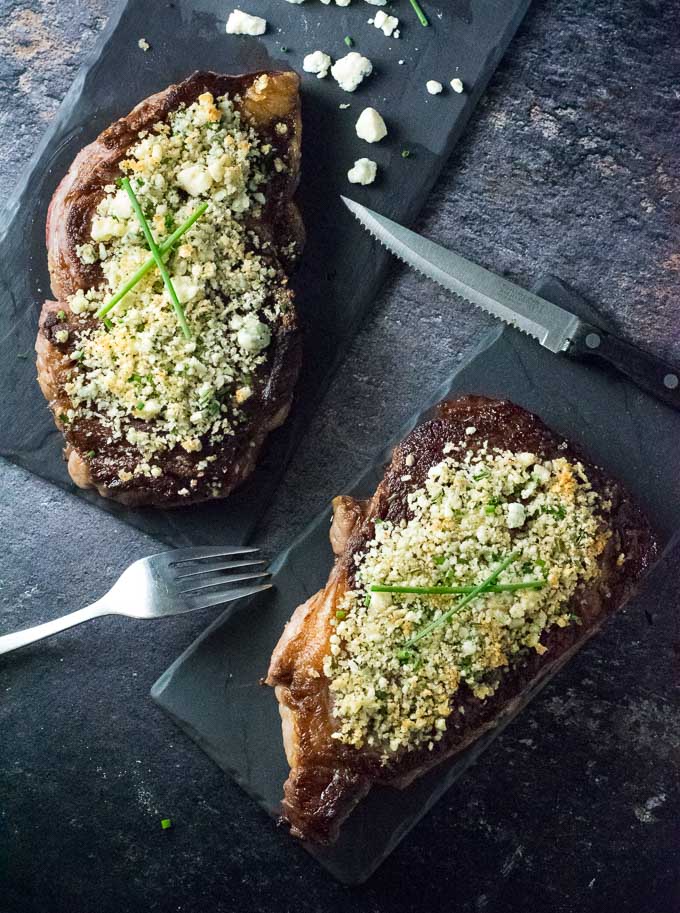 Serving steaks topped with blue cheese crust.