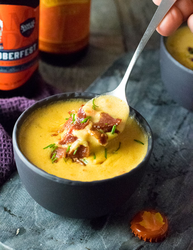 Spoonful of beer cheese soup with bacon.