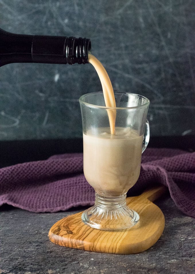 Pouring Baileys Irish Cream into Spiked Hot Chocolate.