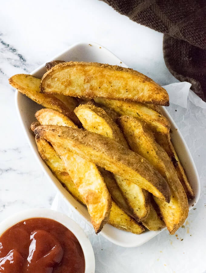 A white bowl with oven steak fries.