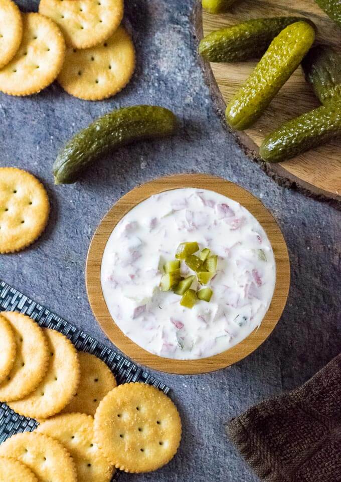 Pickle wrap dip with crackers and dill pickles.