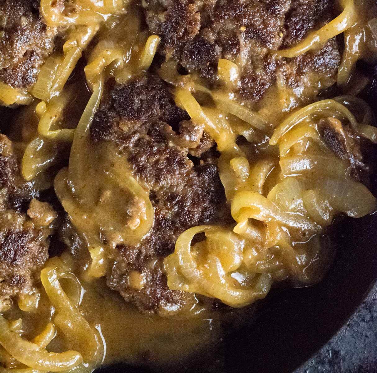 Hamburger steak and onion gravy in cast iron skillet