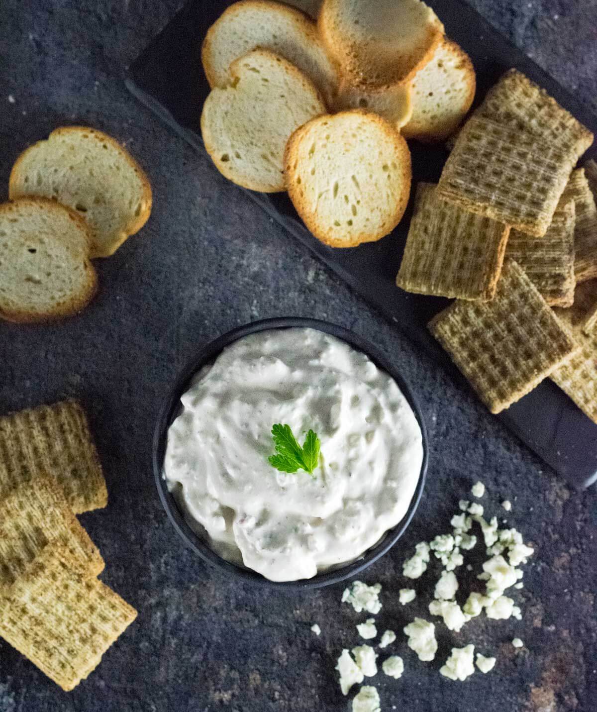 Bacon horseradish appetizer surrounded by bagel chips and crackers.