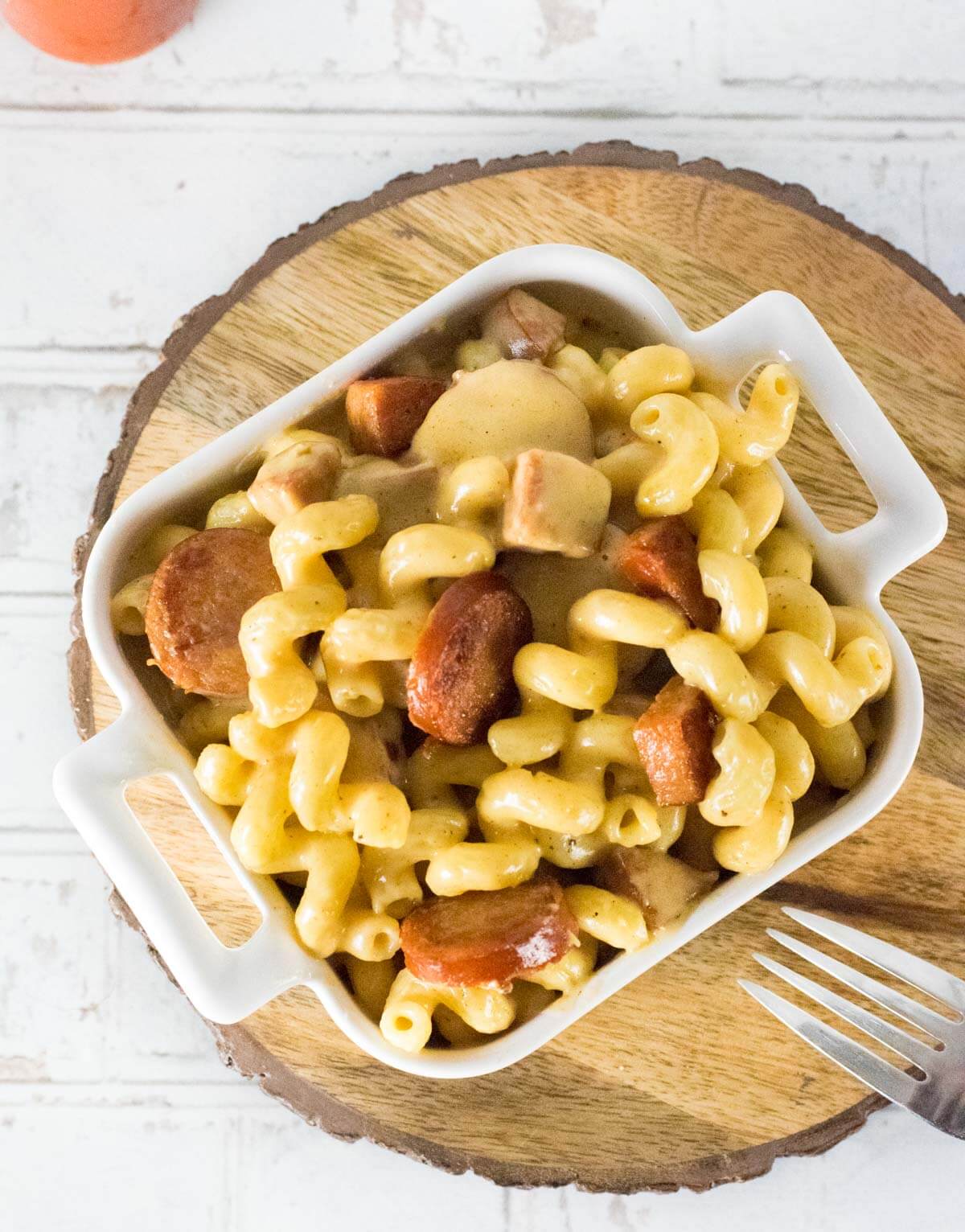 Cajun mac and cheese shown from above on a wooden platter.