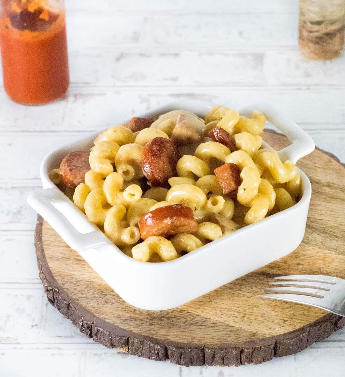 Cajun mac and cheese shown with hot sauce.