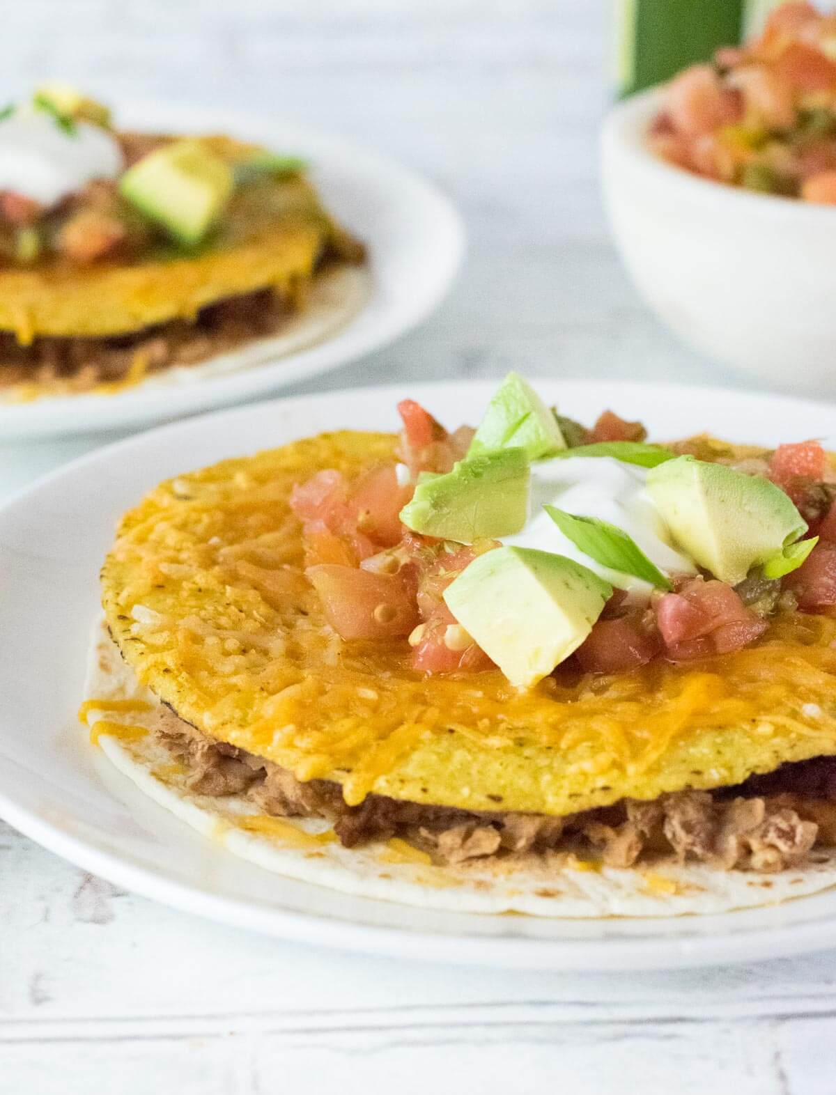 Mexican pizza toppings shown with avocado, tomato, sour cream.