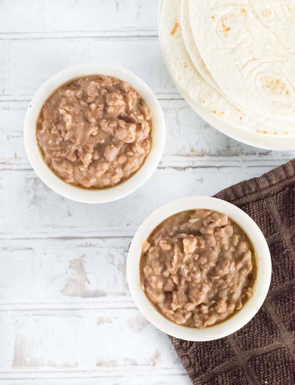 Refried beans shown next to flour tortillas.