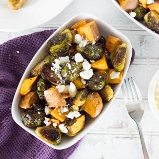 Sweet potatoes and Brussels sprouts in a white dish viewed from above