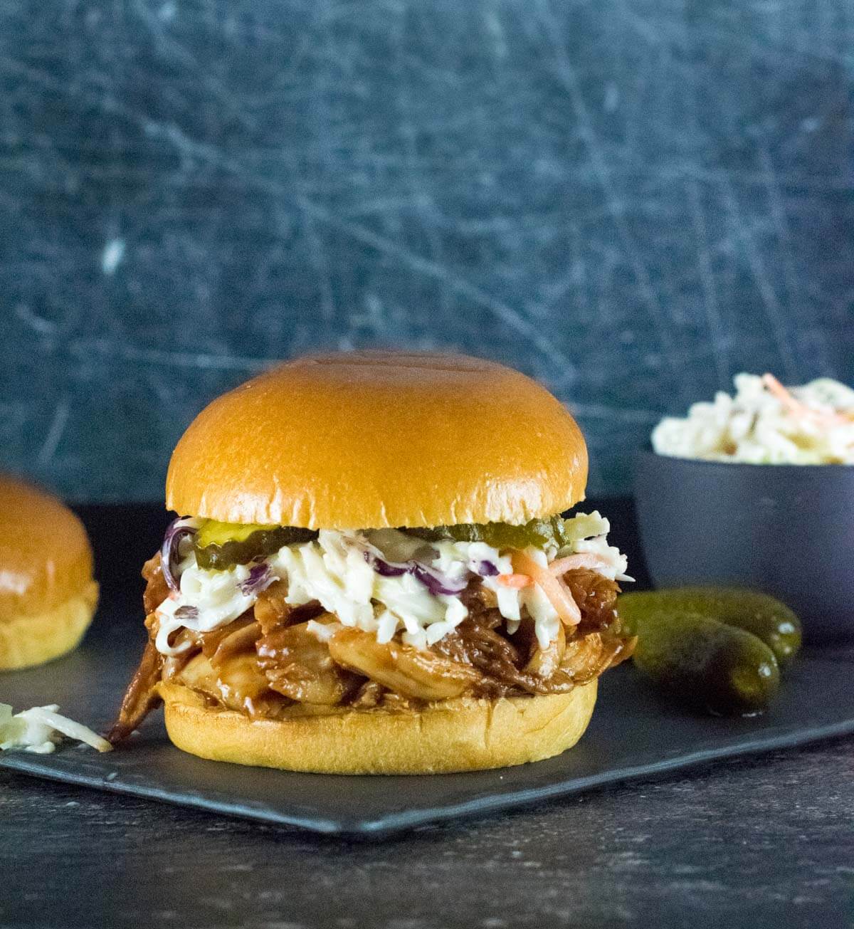 BBQ Chicken Sandwich topped with cole slaw and pickles.