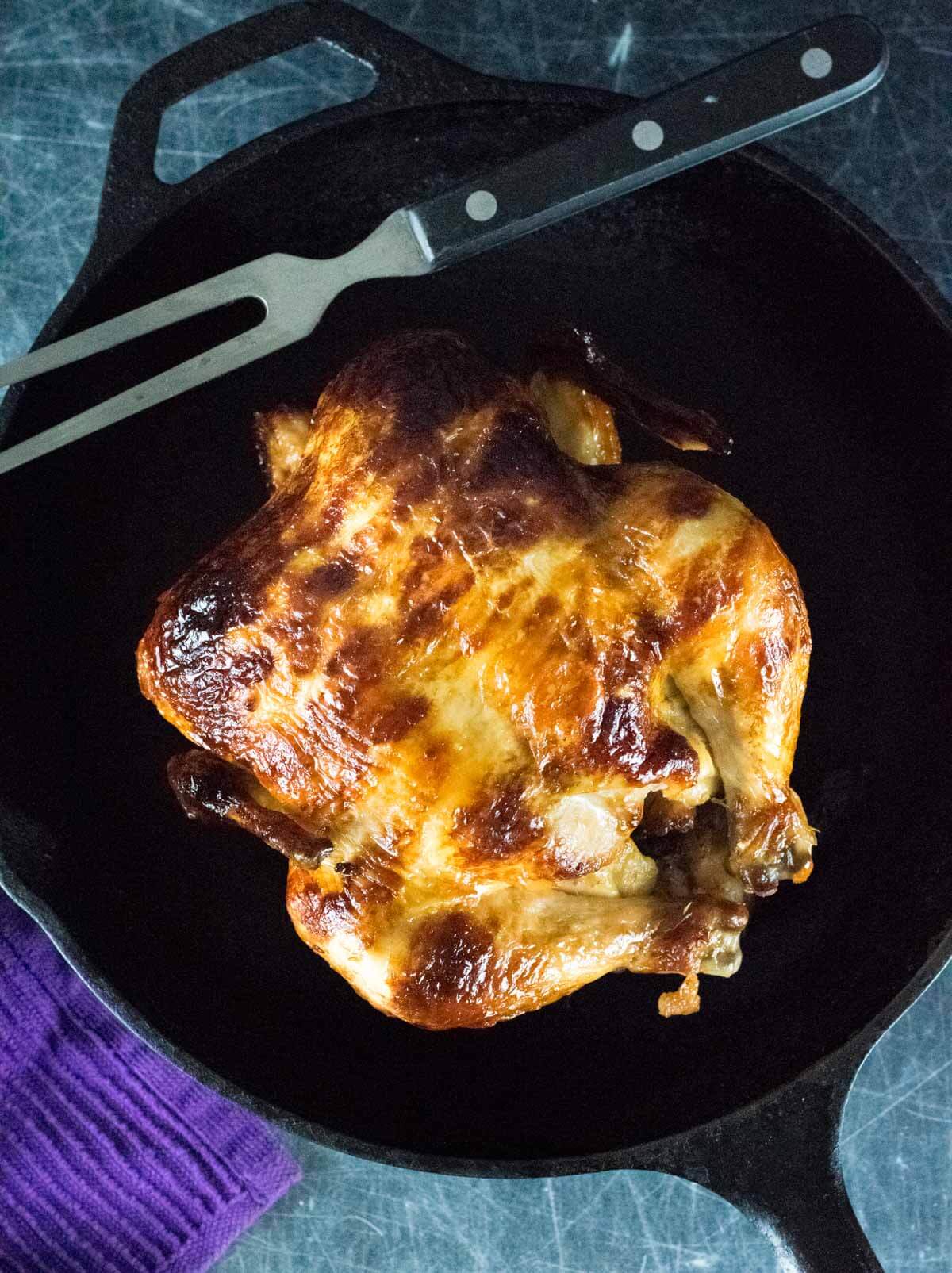 Homemade Rotisserie Chicken in the oven in cast iron.