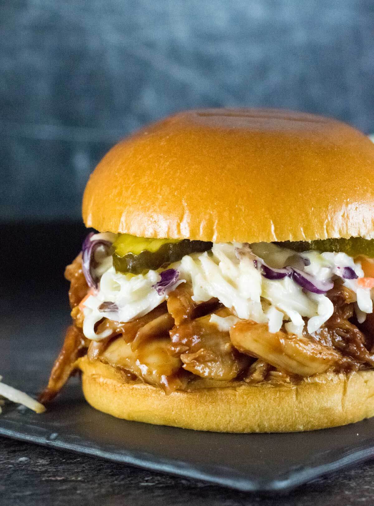Shredded BBQ Chicken Sandwich with coleslow on top.