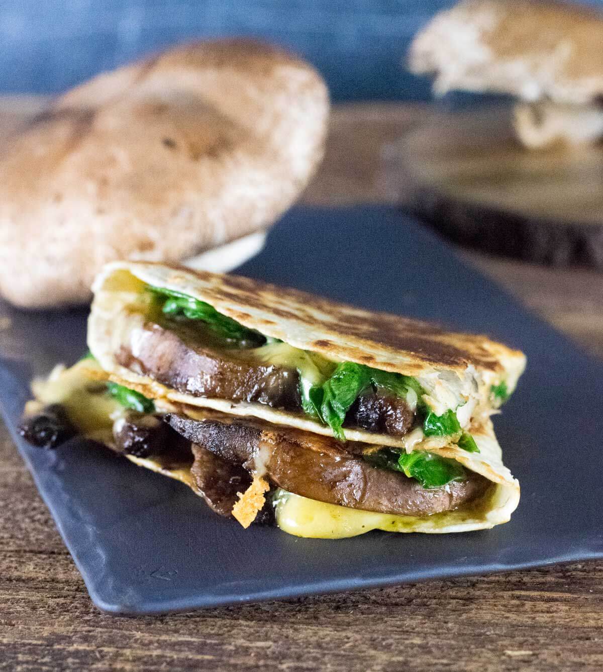 Spinach and Mushroom Quesadillas on black stone.