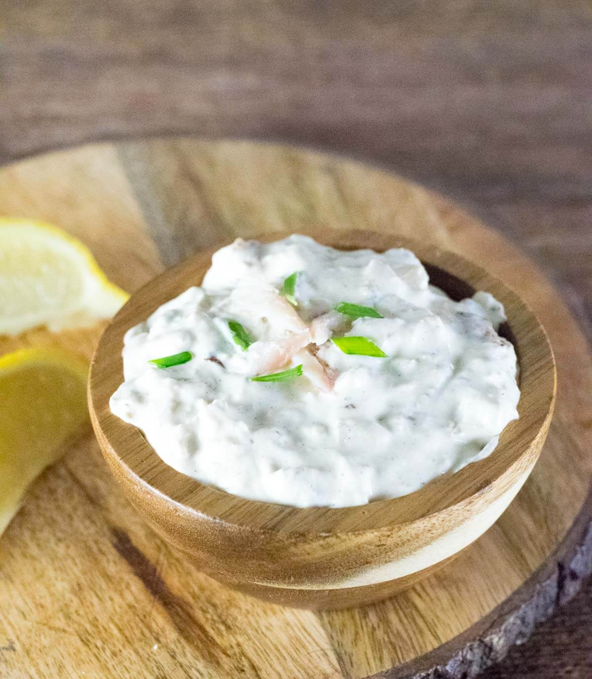 Trout dip with chives on top and lemon wedges shown.