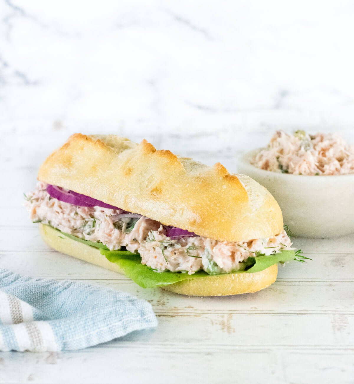 Salmon Salad Sandwich on hoagie roll with lettuce.