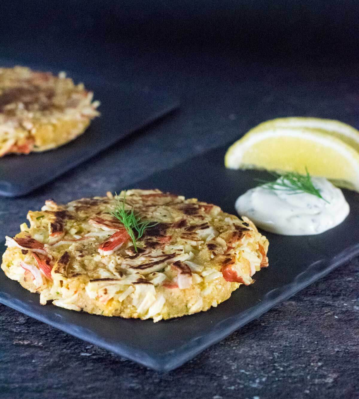 Close up of crab cakes and dipping sauce.