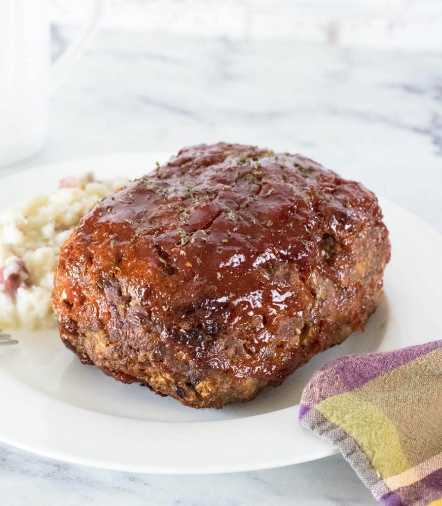 Bison Meatloaf on white plate with mashed potatoes.