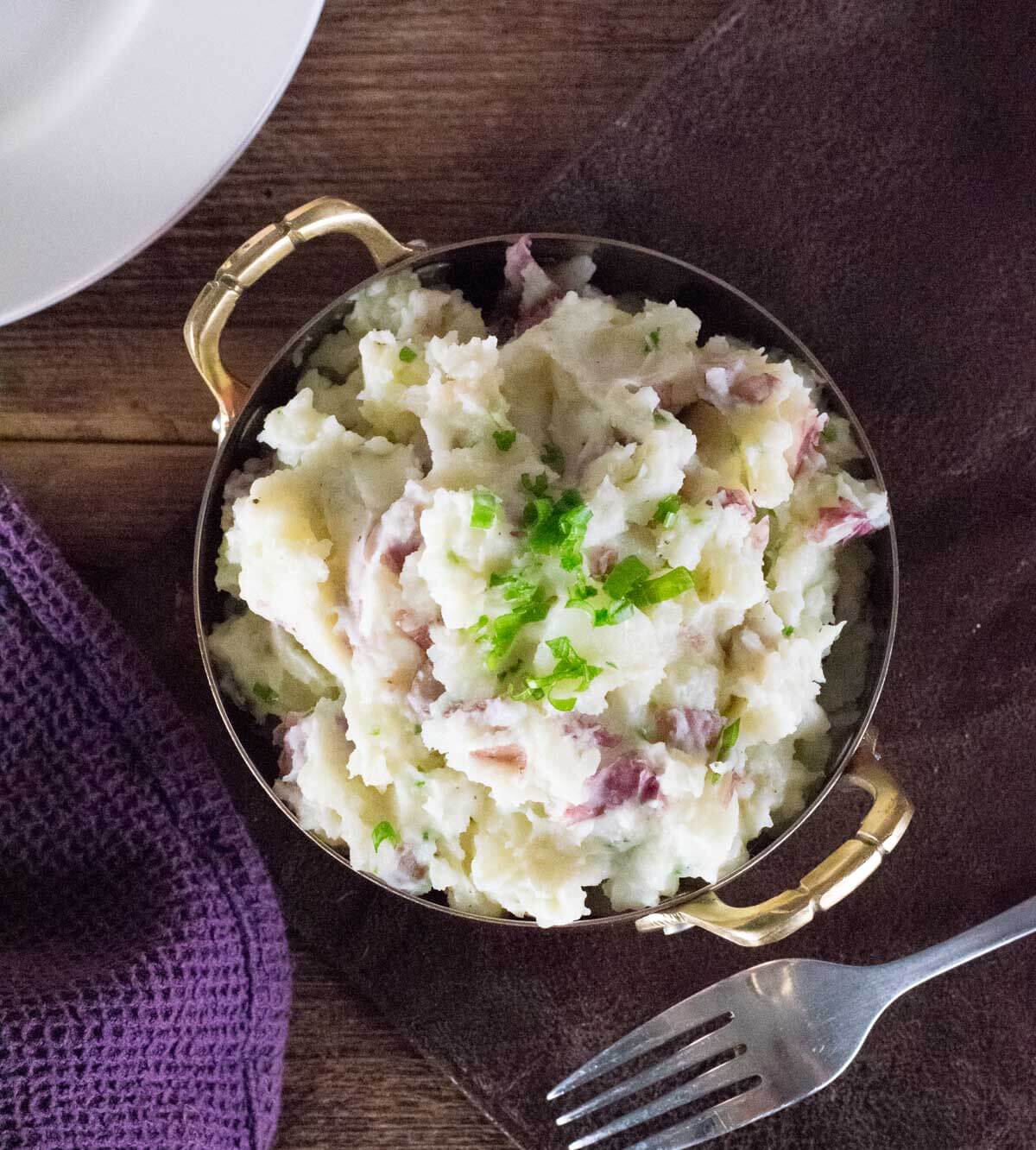 Mashed red potatoes on table viewed from above.