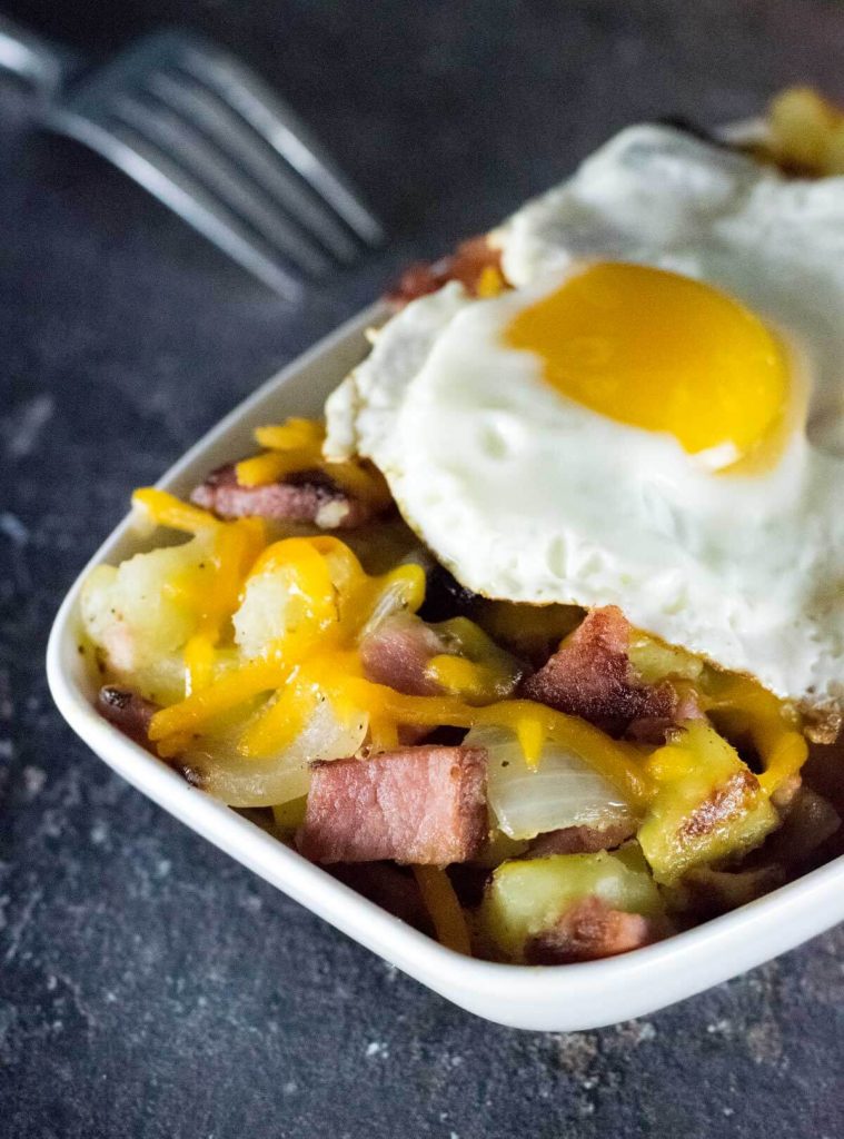 Ham and potato hash topped with cheese and a fried egg.