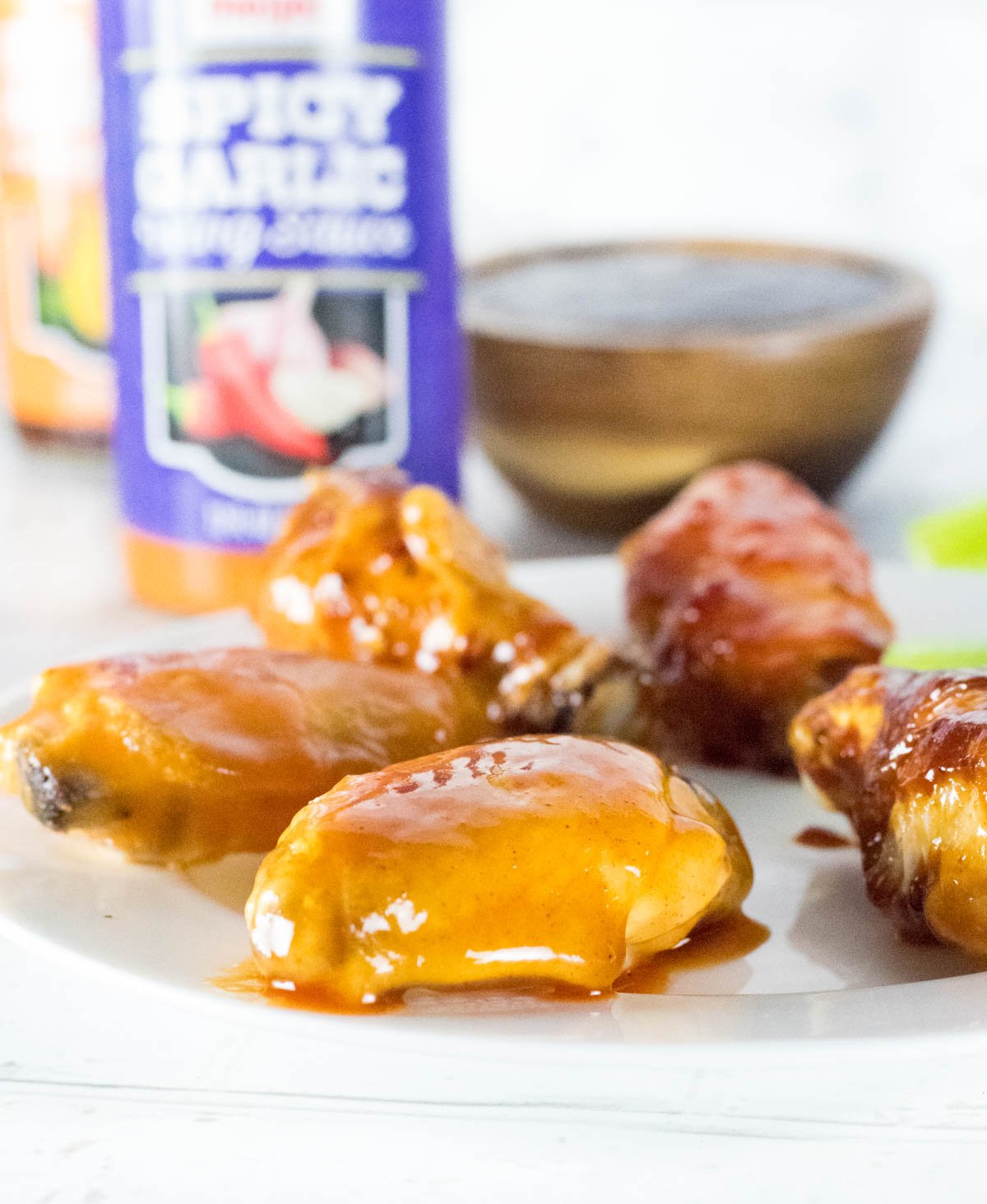 Sauced Chicken Wings with sauce bottle behind.