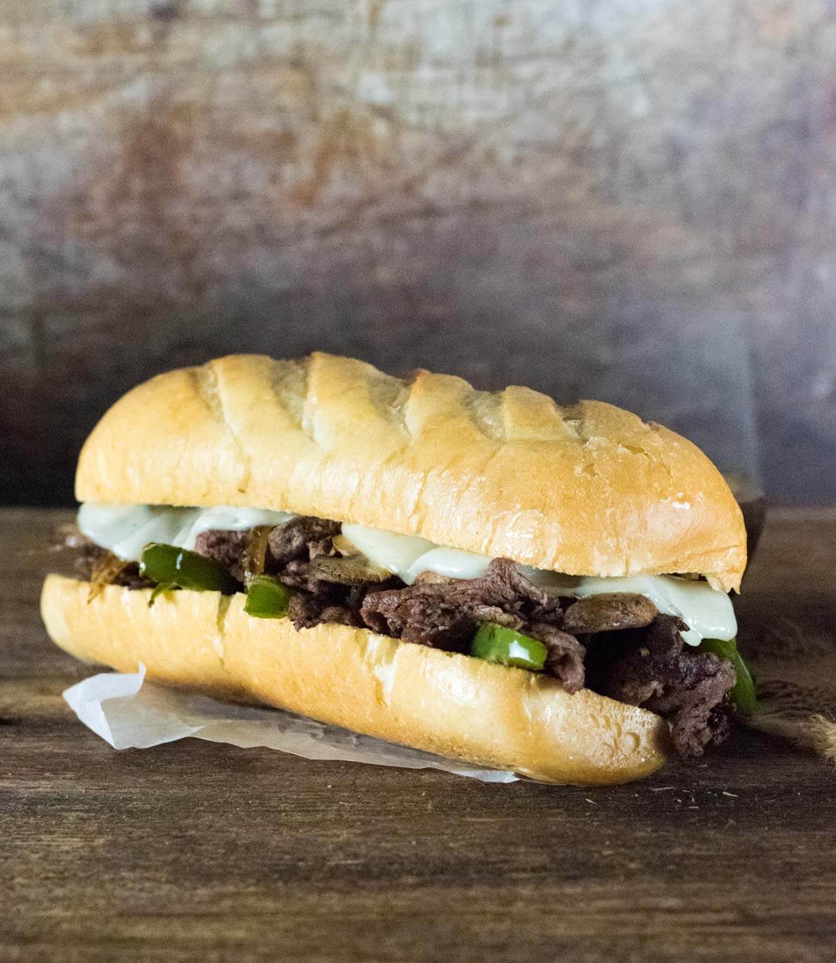 Venison Cheesesteak on wooden board viewed from the side.