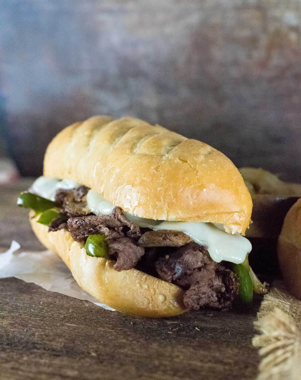 Venison Philly Cheesesteak viewed close up on wax paper.