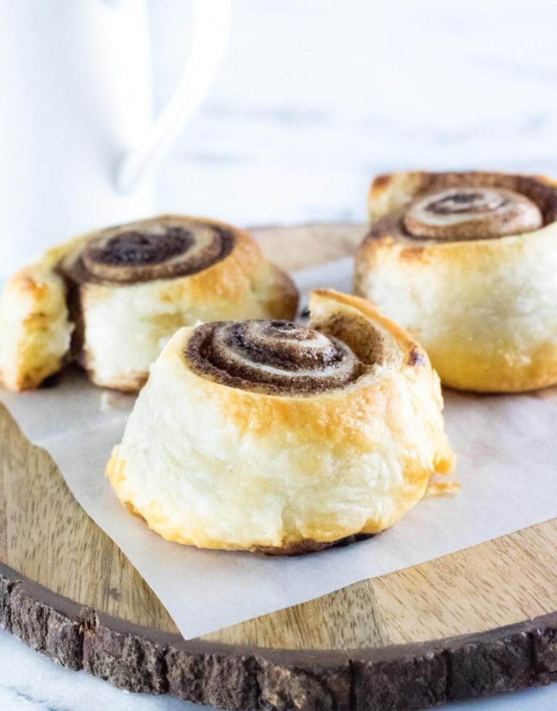 Cinnamon rolls without icing sitting on wax paper.
