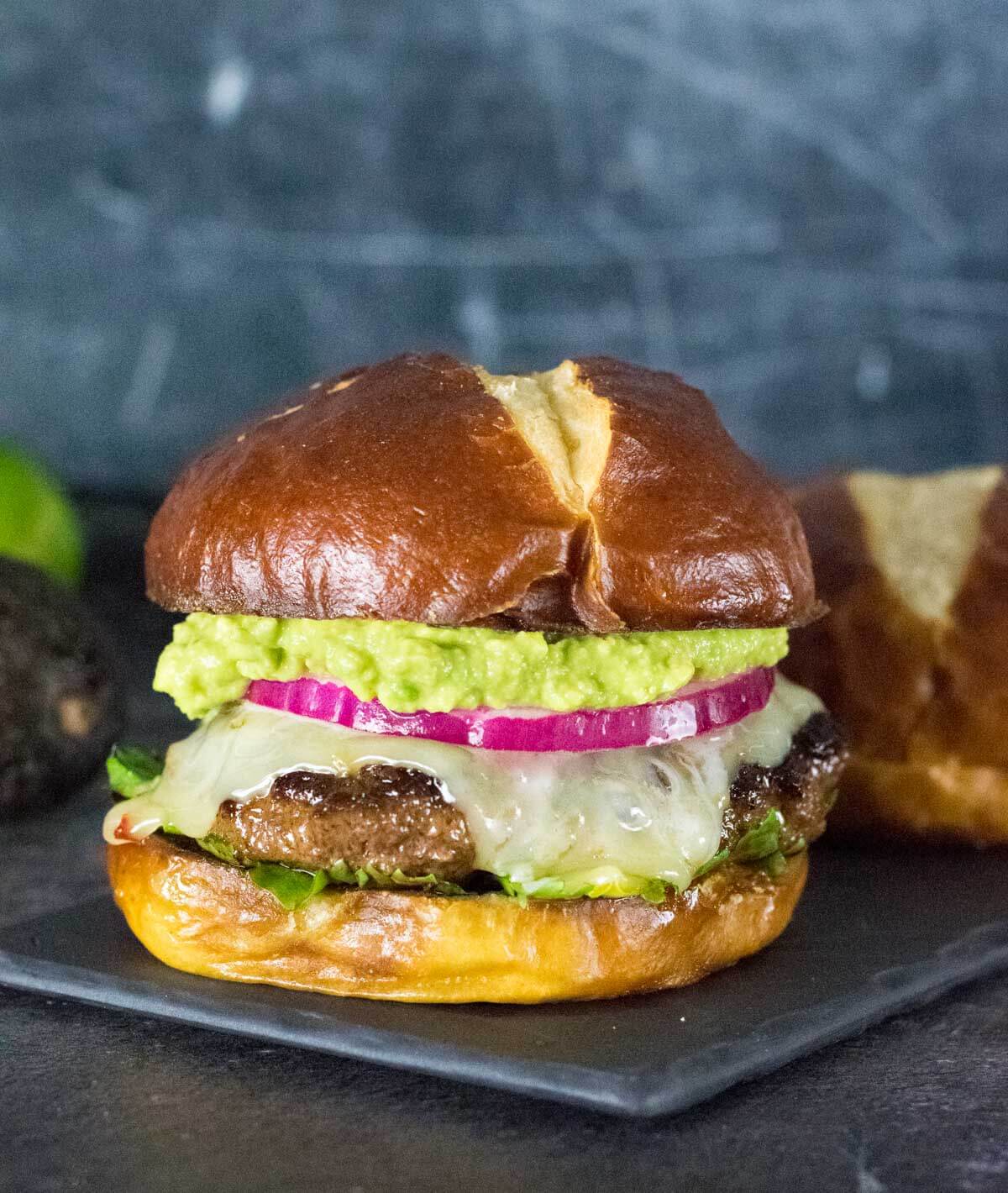 Mexican Chorizo Burger with pretzel bun on black tray