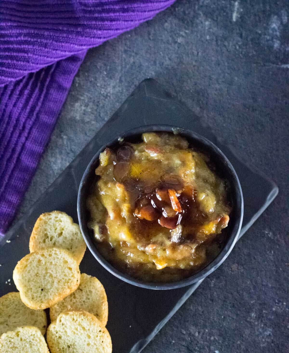 Smoky bacon dip in a black bowl viewed from overhead.