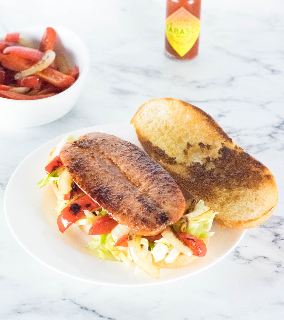 Split andouille sausage on hoagie roll viewed from above.