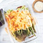 Cheesy asparagus viewed from above with Parmesan alongside.