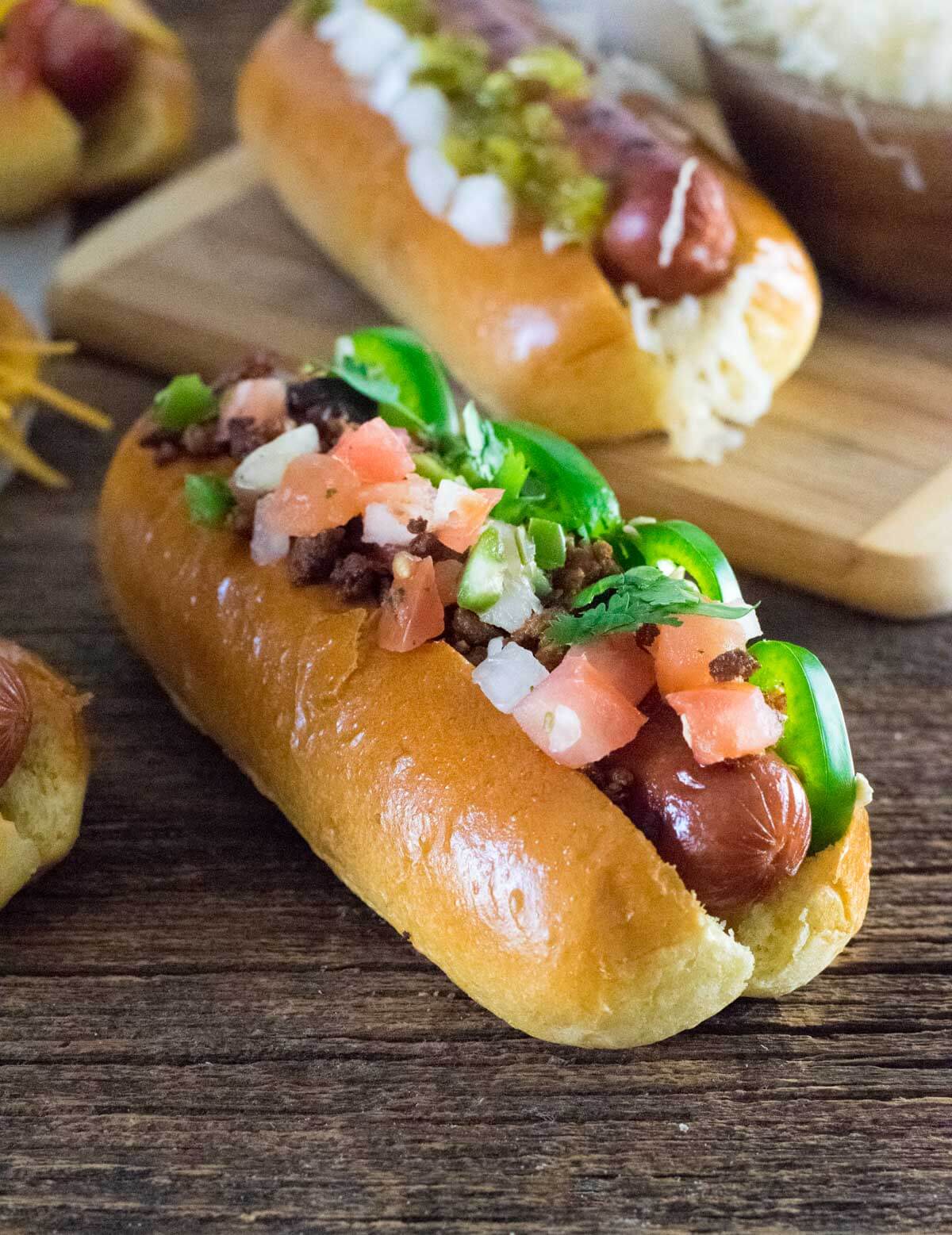 Loaded Tex-Mex hot dog on wooden tray.